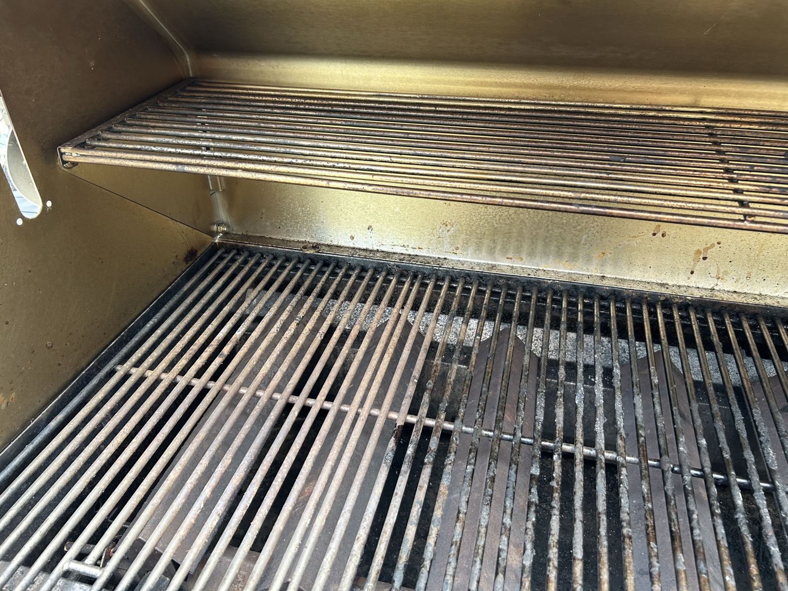 BBQ interior before service — fire-stained grates and warming rack